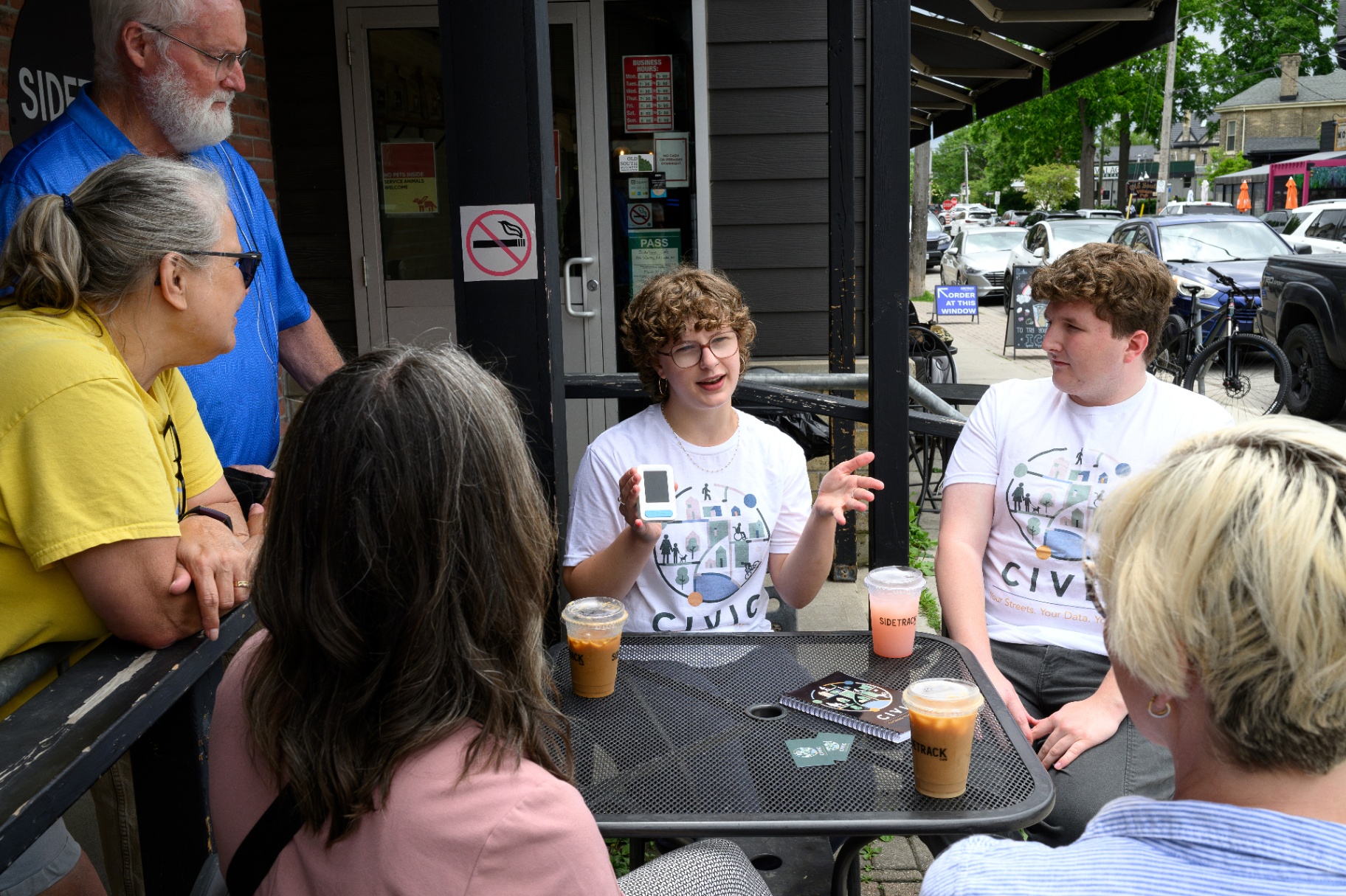 CIVIC team member demonstrates a Telraam sensor to community members at Sidetrack Cafe in London, Ontario.